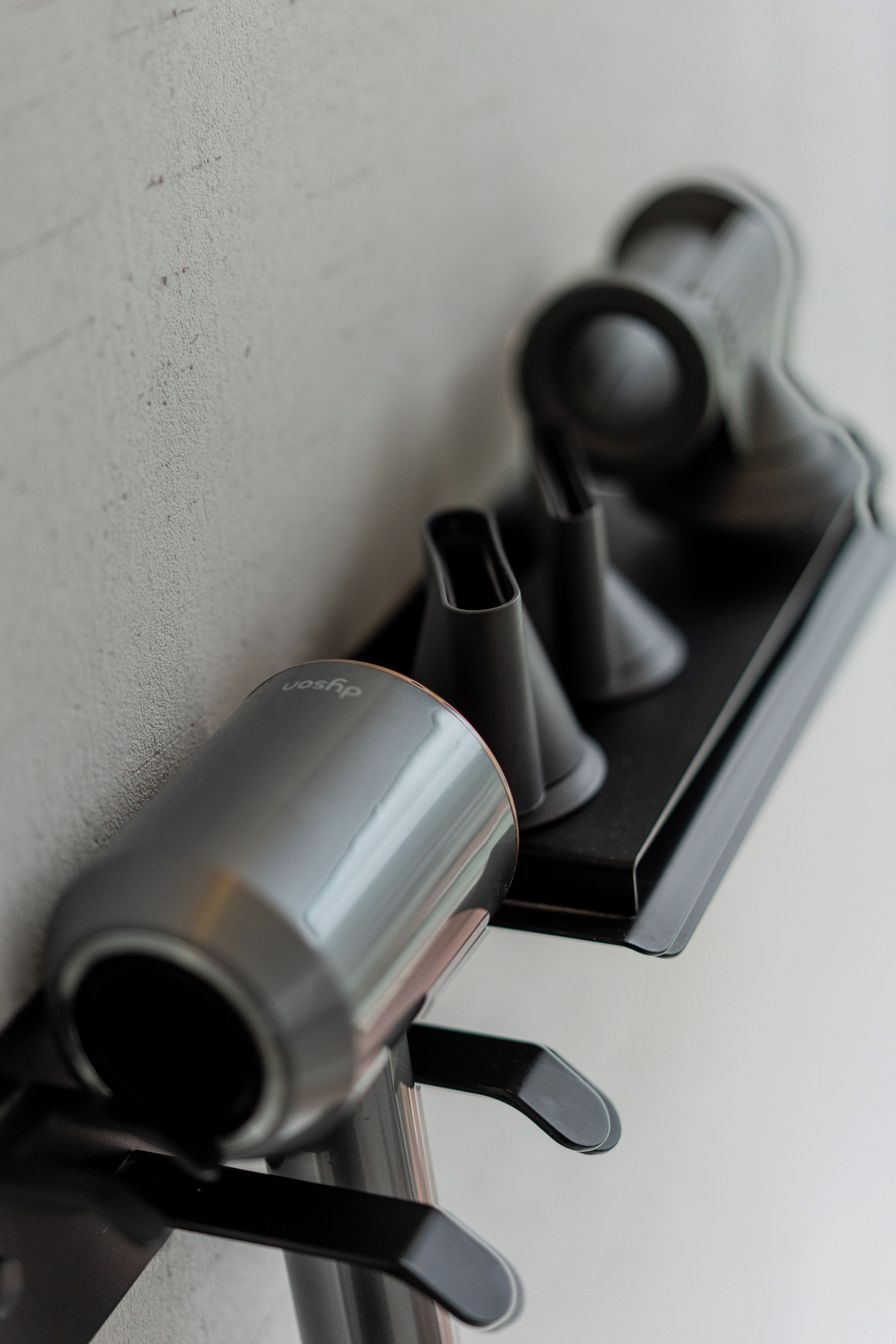 A black, metallic, cylindrical object with a label, possibly a part of a piece of furniture or equipment.