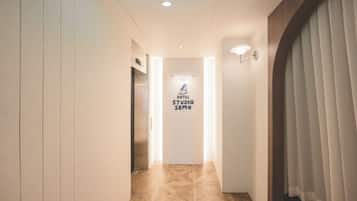 Ein Hotelkorridor mit einem Schild, auf dem 'HOTEL STUDIO SEMO' steht, und einem modernen Aufzug.