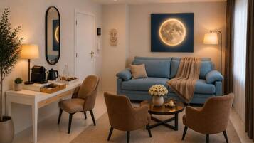 A modern living room with a sofa, armchairs, a coffee table, and a desk with a lamp.