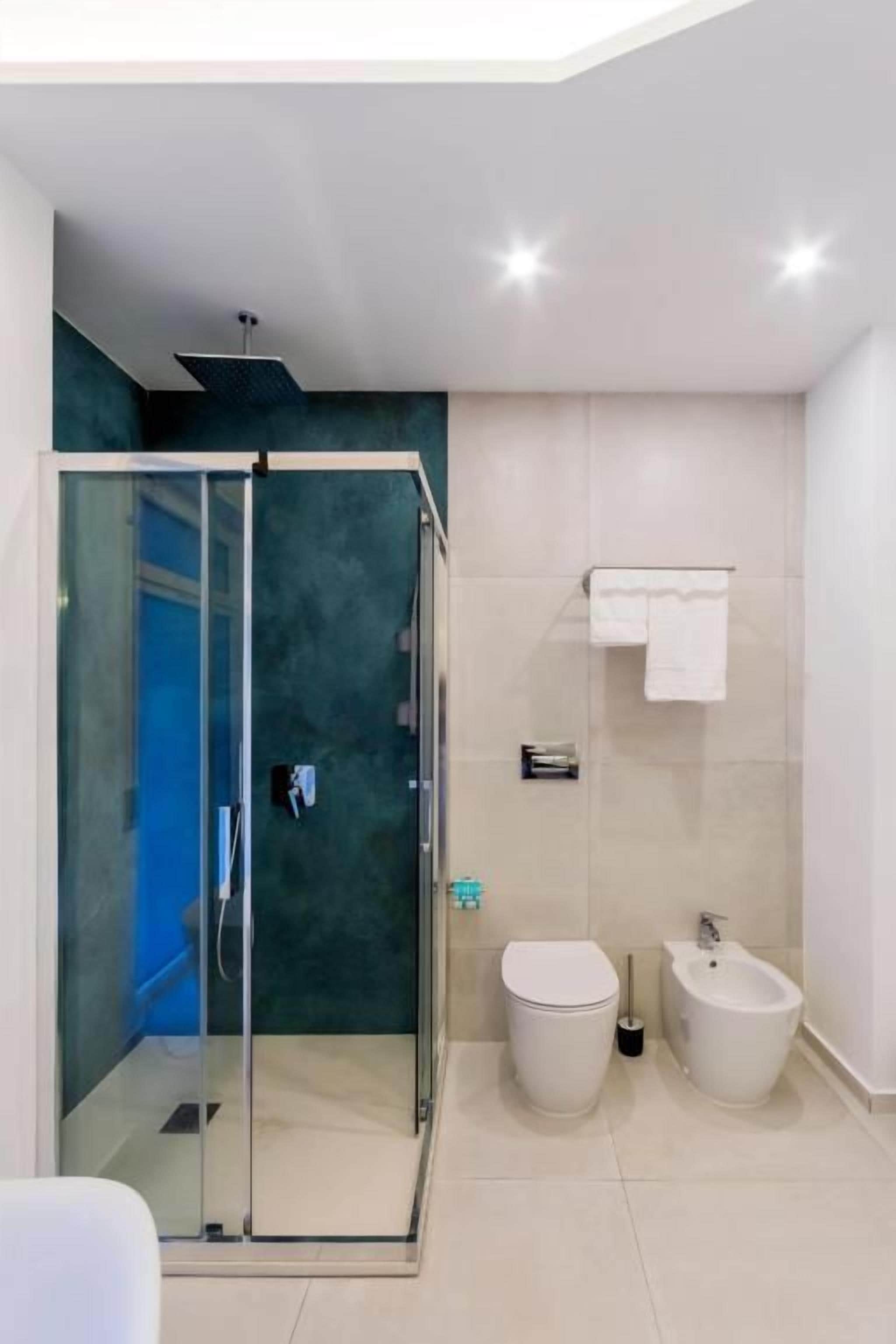 Une salle de bain moderne avec une douche à parois de verre, des toilettes et un bidet.