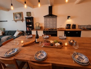 A dining area with a wooden table set for six, surrounded by chairs. - A charming house in downtown Eymet, ideal for 6 people. (Eymet)