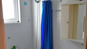 A bathroom with a bathtub, a shower, a sink, and a window. - Vrbo Property (Skouloufia)