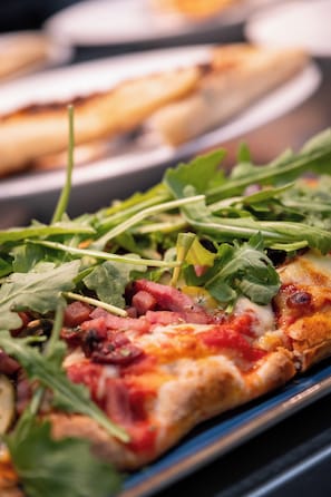 A pizza with toppings and a plate of bread.