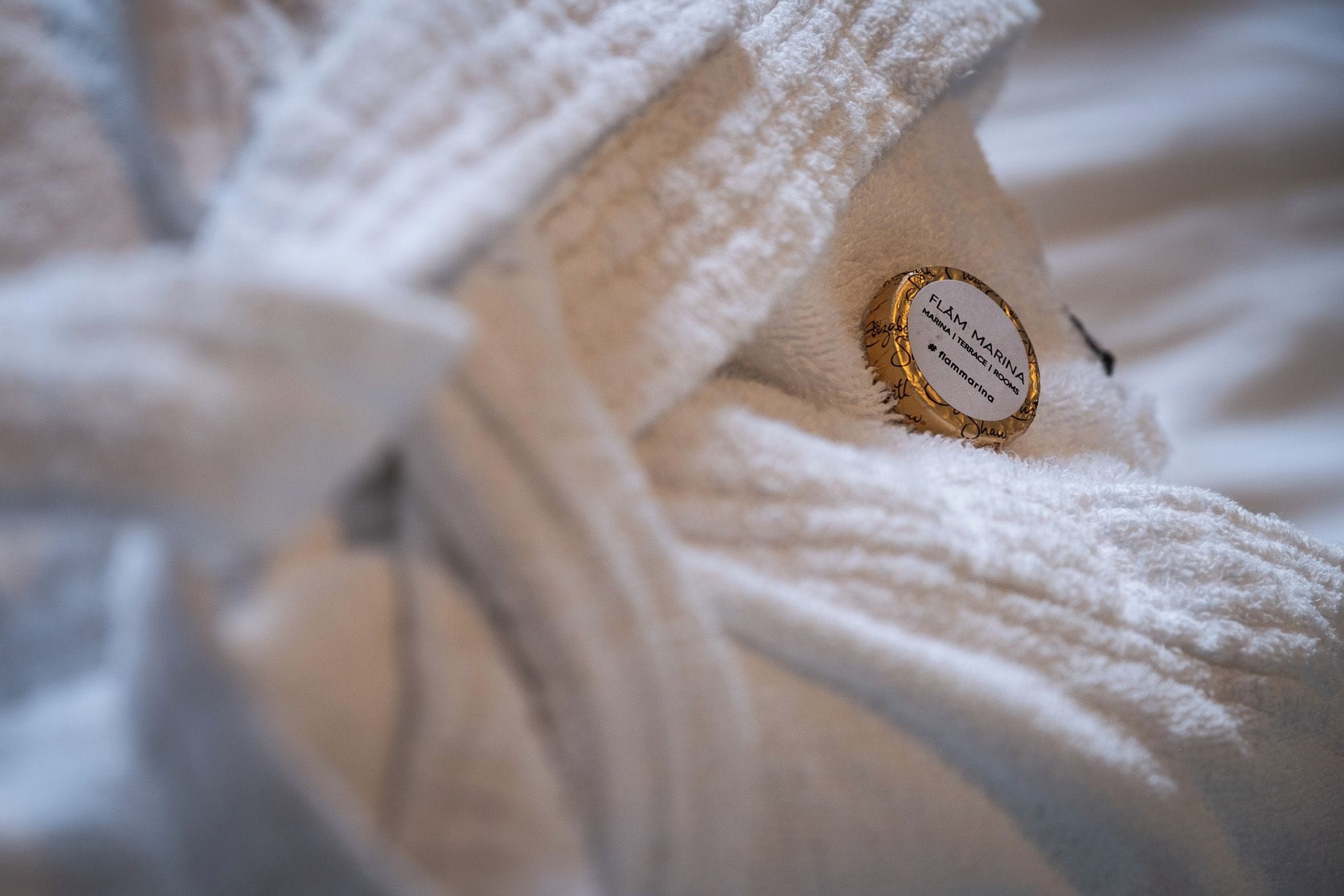 A white bathrobe with a label that reads 'FLAM MARINA MARINA I TERRACE ROOMS.'