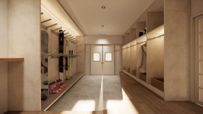 A hallway with a shoe rack, a mirrored closet, and a double door.