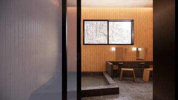 A modern bathroom with a wooden wall, a large window, and a bathtub.
