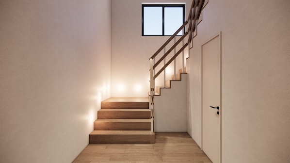 A staircase with wooden steps and a metal railing leading to a door.