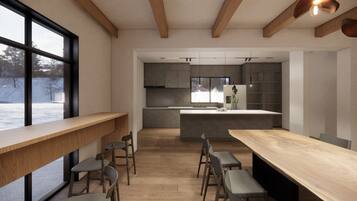 A modern kitchen with a central island, wooden beams, and a large window.