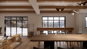 Un interior moderno con una gran mesa de comedor de madera, múltiples sillas, un banco empotrado y amplios ventanales que ofrecen vistas a un paisaje nevado.