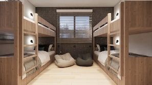 Ein kleines Zimmer mit Etagenbetten, einem Fenster und einer kleinen Sitzecke.