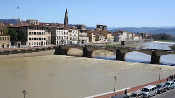 Un río con un puente, edificios y cielo despejado.