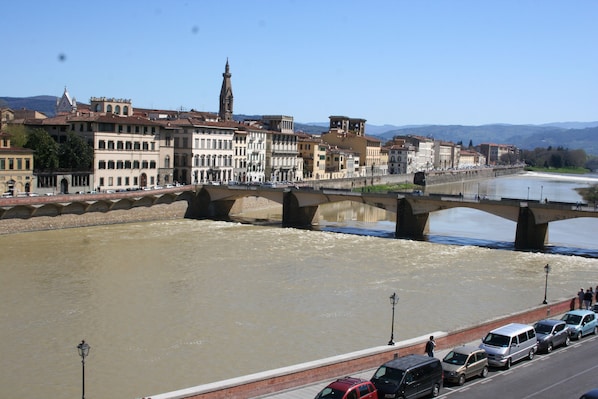 Un río con un puente, edificios y cielo despejado.