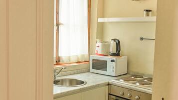 A compact kitchen with a sink, a microwave, and a stove.
