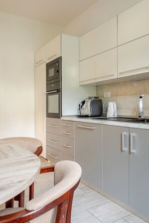 A modern kitchen with a built-in oven, microwave, and coffee maker. - Apartments Morski Svet Portorož (Piran)
