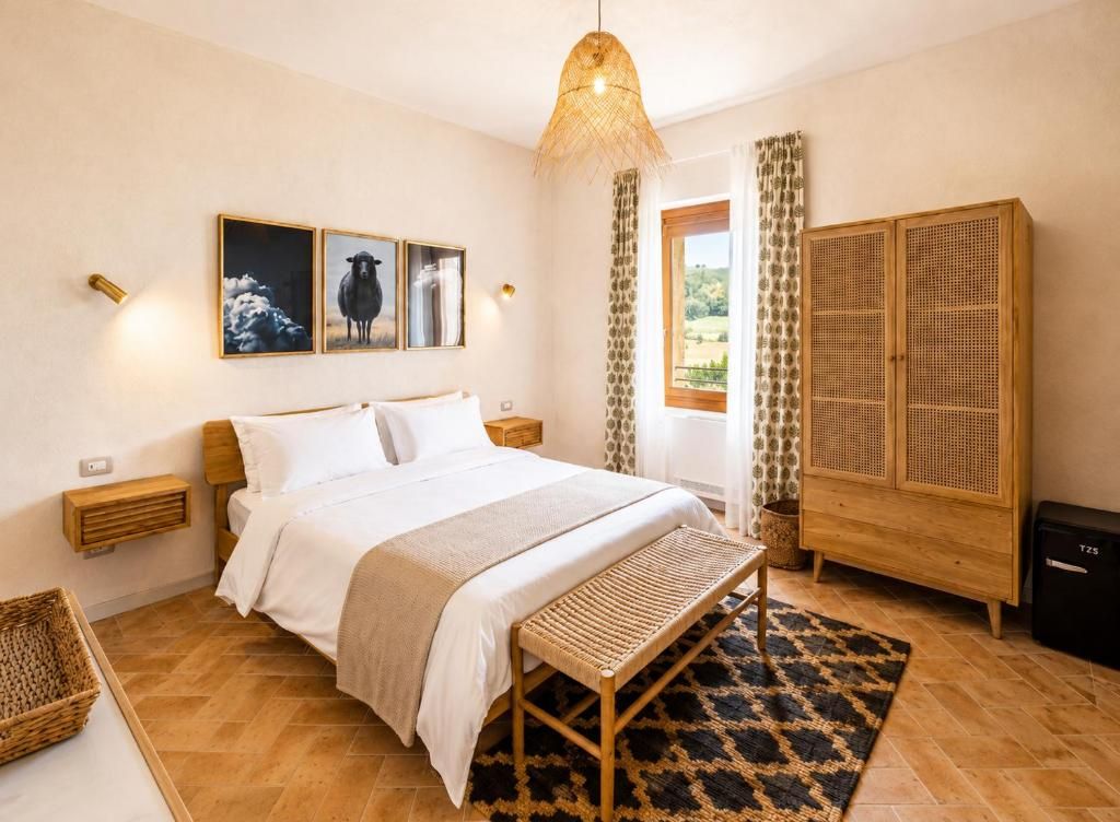 Een slaapkamer met een bed, nachtkastjes, een bankje, een garderobe en een raam met gordijnen.