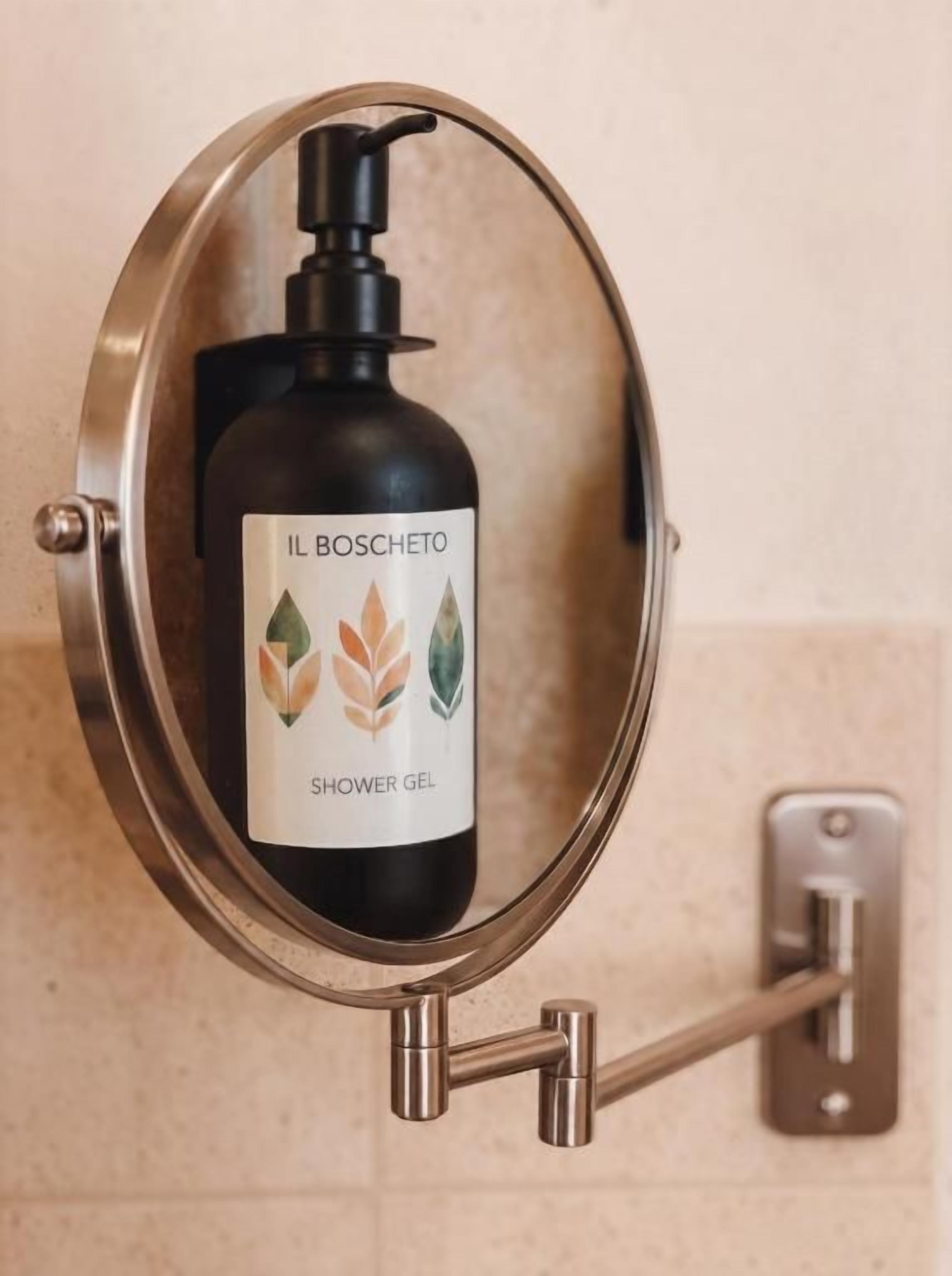 Eine Duschgelflasche mit dem Aufdruck 'IL BOSCHETO' auf einem Wandhalterung befestigt.