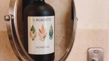 Eine Duschgelflasche mit dem Aufdruck 'IL BOSCHETO' auf einem Wandhalterung befestigt.