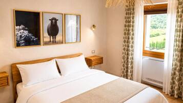 Une chambre d’hôtel avec un grand lit, deux tables de chevet, une lampe fixée au mur et une fenêtre avec des rideaux.