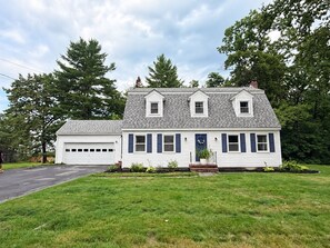 A two-story house with a garage, a front porch, and a well-maintained lawn. - Charming Waterville Home on Quiet Street. Fully Furnished (Waterville)