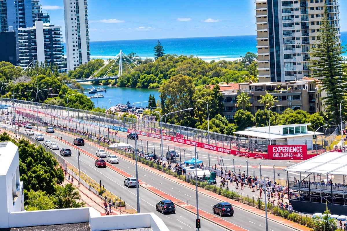 Un paisaje urbano costero con un puente, edificios altos y un evento de maratón.