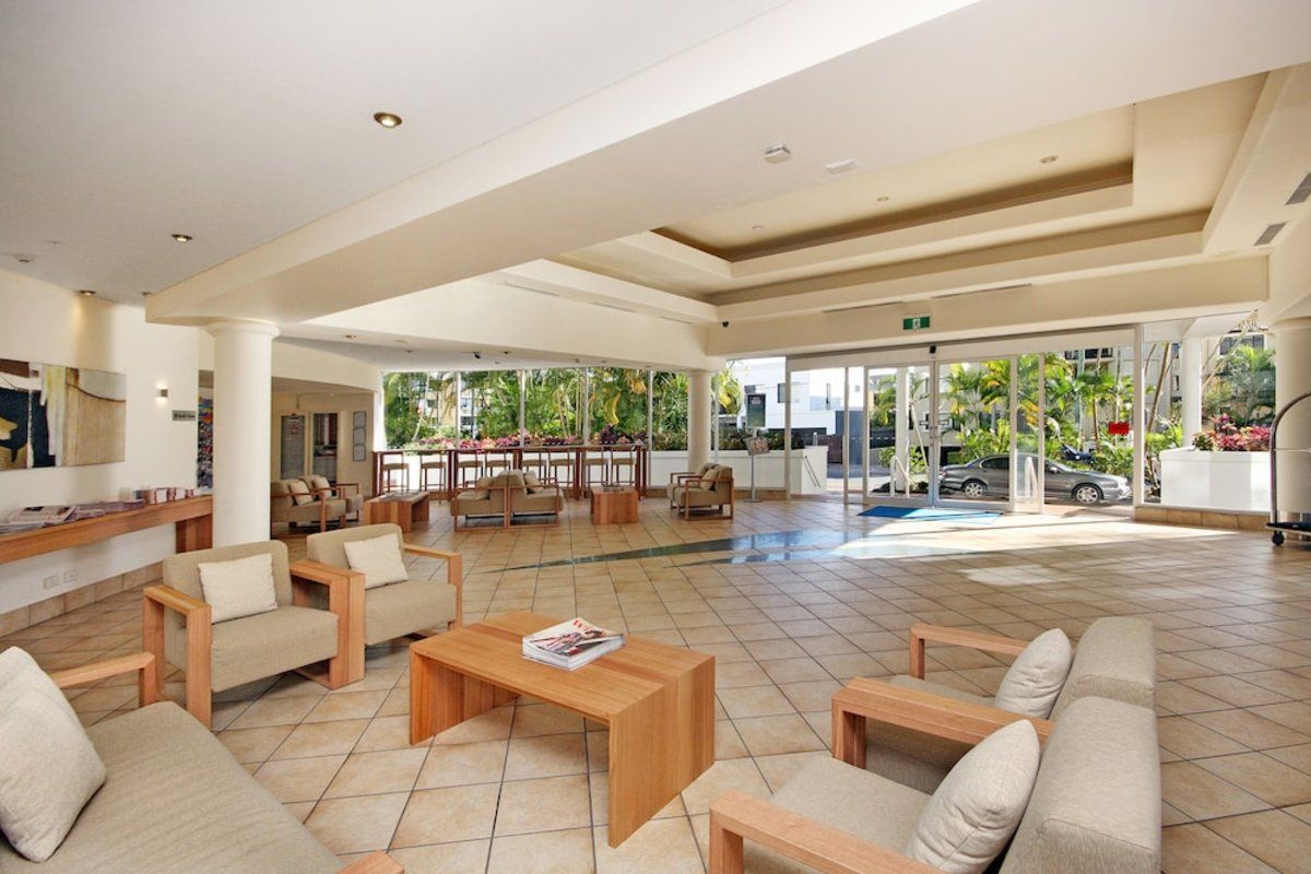 A spacious lobby with seating areas, a reception desk, and a view of the outside.