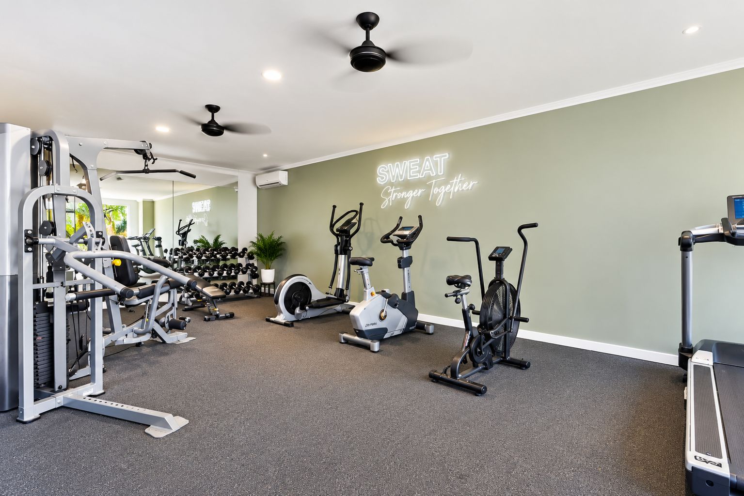 A gym with various exercise equipment, including treadmills, stationary bikes, and weight machines.