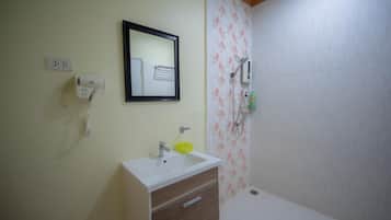 A bathroom with a sink, mirror, and shower.