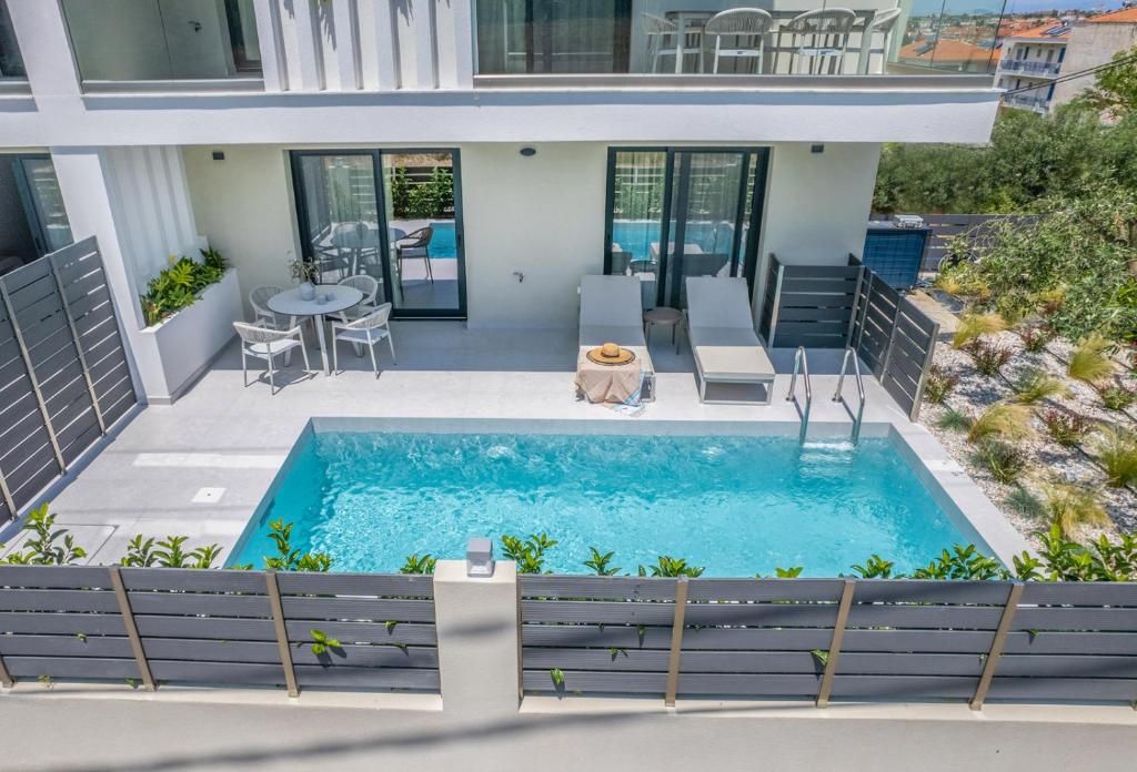 Un bâtiment moderne doté d’une piscine, d’un espace extérieur aménagé et offrant une vue sur les environs.