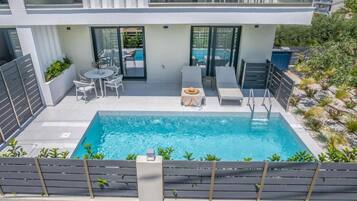 Un bâtiment moderne doté d’une piscine, d’un espace extérieur aménagé et offrant une vue sur les environs.
