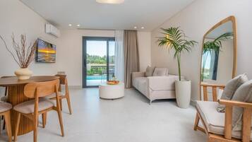 A modern living room with a dining area, a sofa, a coffee table, and a large mirror.