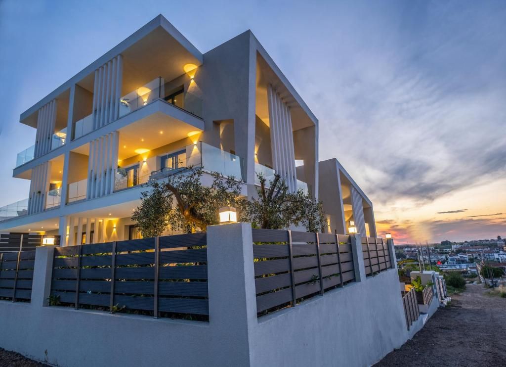 Un immeuble moderne à plusieurs étages, doté de balcons et d’un éclairage extérieur.
