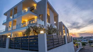 Un immeuble moderne à plusieurs étages, doté de balcons et d’un éclairage extérieur.