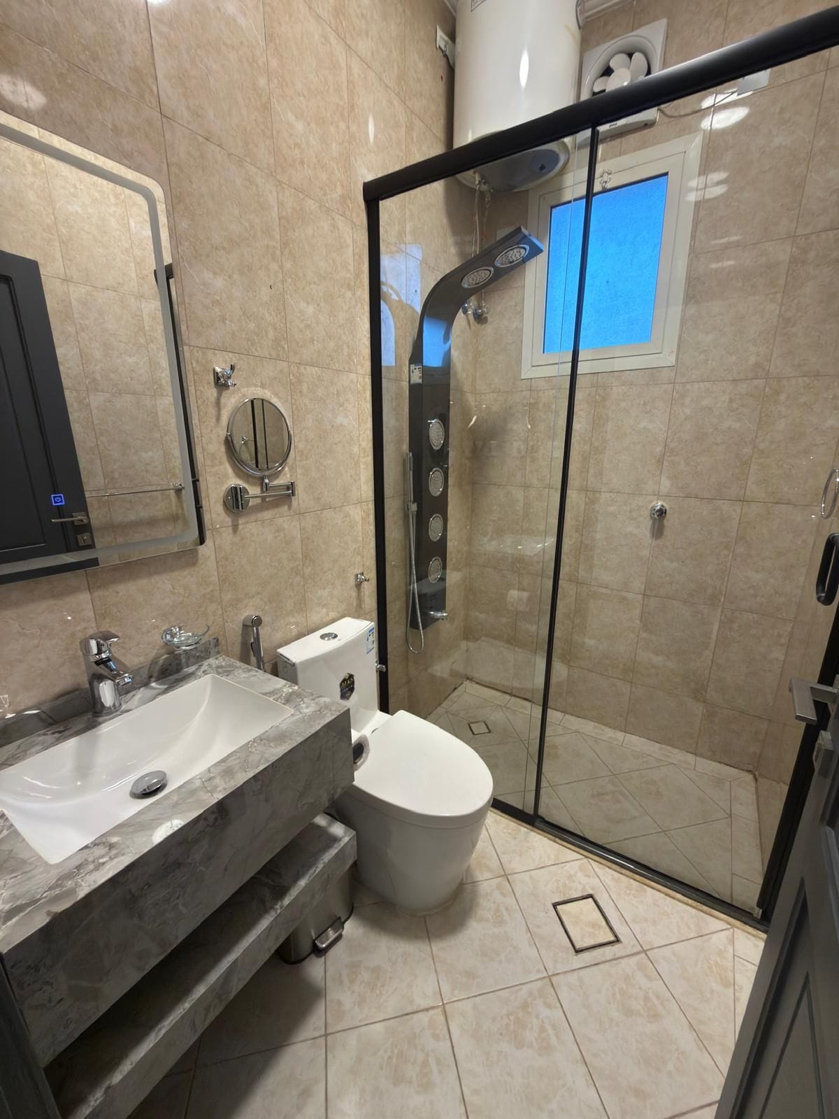 Une salle de bain moderne avec une douche à parois de verre, un meuble-lavabo à deux vasques et des toilettes.