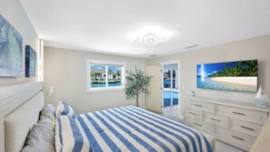 Une chambre à coucher avec un lit, une commode, une fenêtre et un tableau.