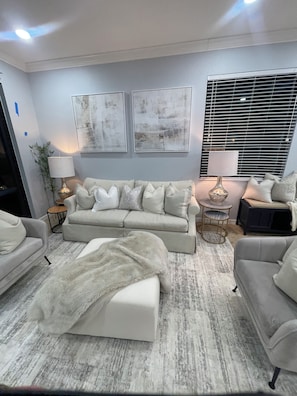 A modern living room with a sofa set, two side tables, a lamp, and abstract wall art. - Cozy 2-bedroom condo in perfect Naples with cool AC (Naples)