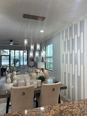 A modern dining area with a granite countertop, a dining table, and chairs. - Cozy 2-bedroom condo in perfect Naples with cool AC (Naples)