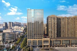 A high-rise building with a modern glass facade, surrounded by other residential and commercial structures. - XINYUANYUSHANG GRANDHOTELCHANGSHA (Changsha)