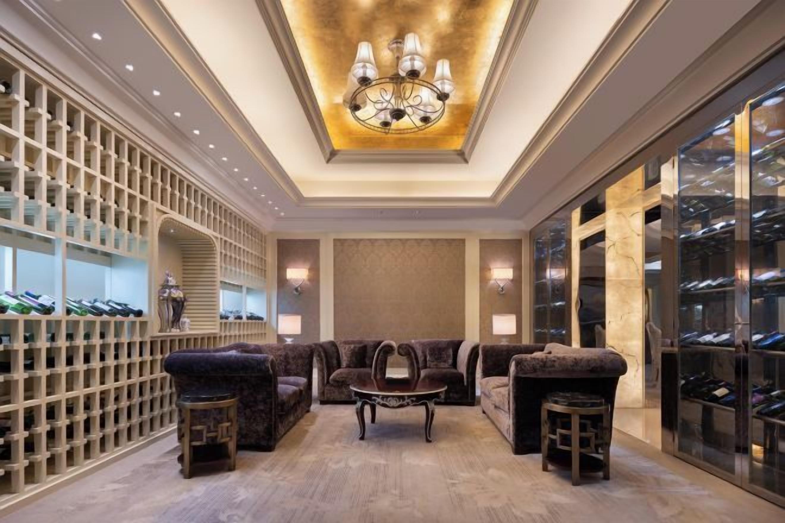 A luxurious interior with a chandelier, seating area, and wine storage.