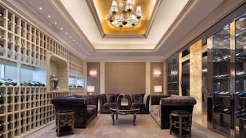 A luxurious interior with a chandelier, seating area, and wine storage.