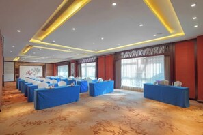 A conference room with rows of tables, a carpeted floor, and a large screen at the front. - XINYUANYUSHANG GRANDHOTELCHANGSHA (Changsha)