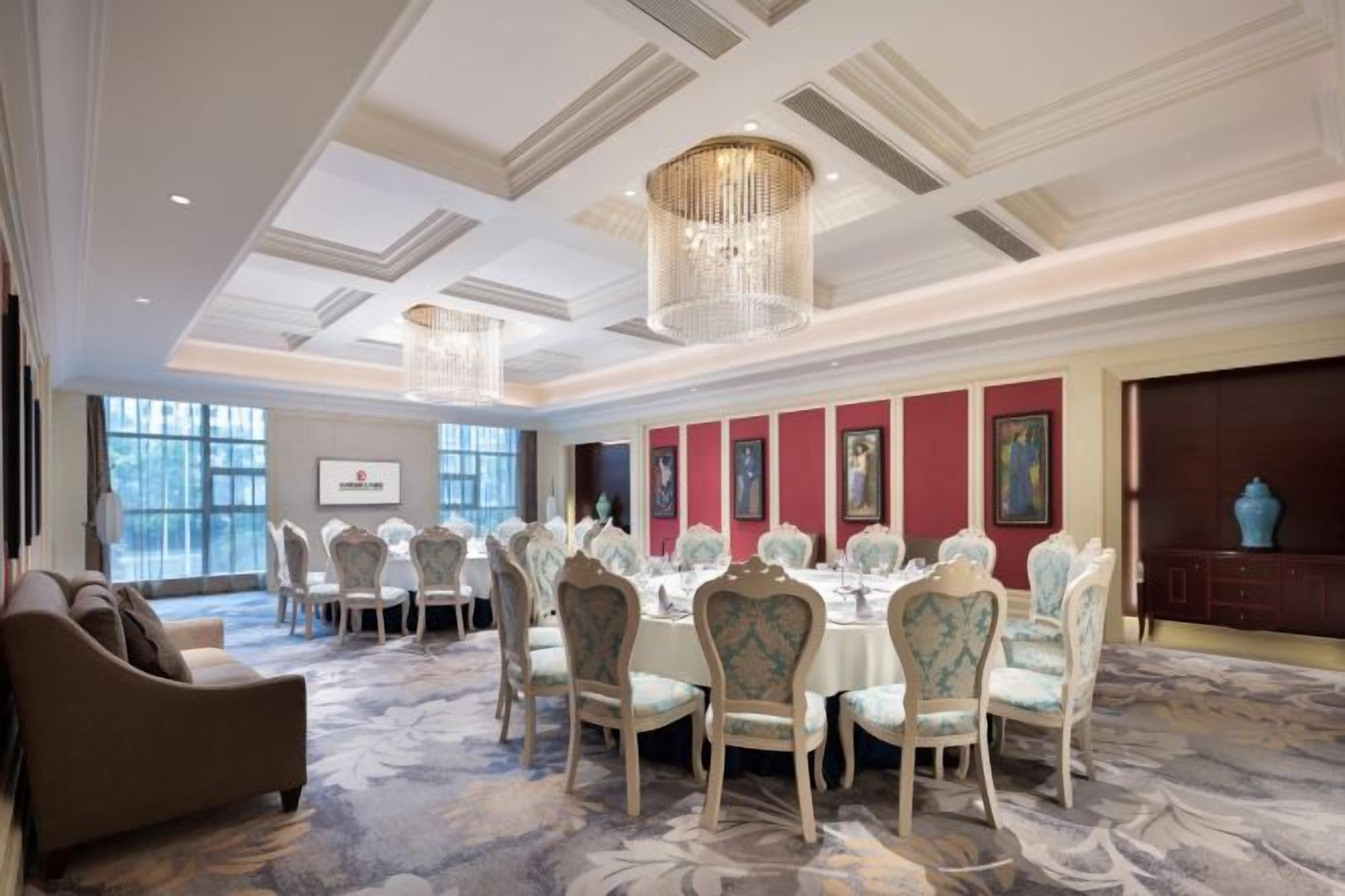 A formal dining room with a long table, chairs, and a chandelier.