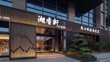 A modern building with a large entrance, signage, and a well-lit facade.