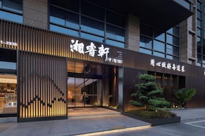 A modern building with a large entrance, signage, and a well-lit facade.