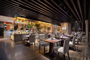 Restaurante moderno com área de bar, piso de madeira e móveis contemporâneos.
