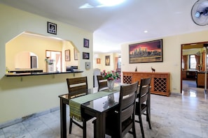 A dining area with a table, chairs, and a vase of flowers. - Classic 5BR Villa with Pool&Gardens(SP1) (Pattaya City,South Pattaya)