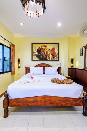 A hotel room with a large bed, a painting on the wall, and a ceiling light fixture. - Classic 5BR Villa with Pool&Gardens(SP1) (Pattaya City,South Pattaya)