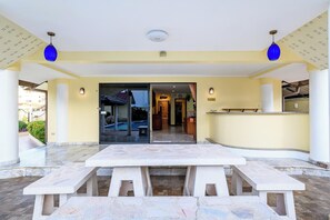 A hotel lobby with a reception desk, a pool area visible through the glass doors, and a marble-tiled floor. - Classic 5BR Villa with Pool&Gardens(SP1) (Pattaya City,South Pattaya)