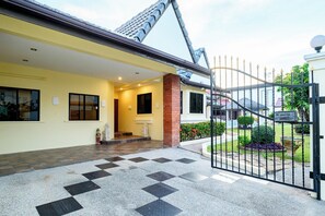 A gated entrance to a residential property with a tiled driveway and a visible staircase leading to the entrance. - Classic 5BR Villa with Pool&Gardens(SP1) (Pattaya City,South Pattaya)