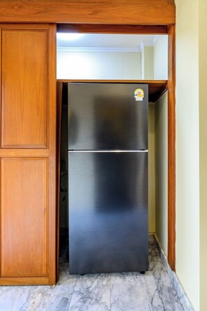 A stainless steel refrigerator in a kitchen with wooden cabinetry and marble flooring. - Classic 5BR Villa with Pool&Gardens(SP1) (Pattaya City,South Pattaya)