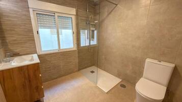 A bathroom with a shower, toilet, and sink.